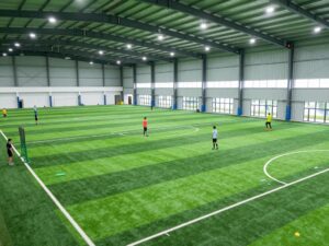 Indoor practice facility at Coastal Carolina University with athletes training.