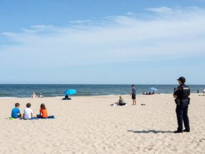 Families enjoying Myrtle Beach with a police officer nearby.