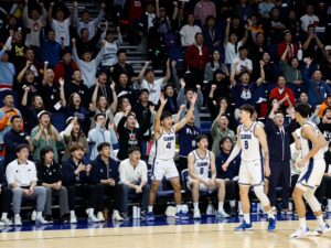 Crowd at a basketball game supporting collegiate teams