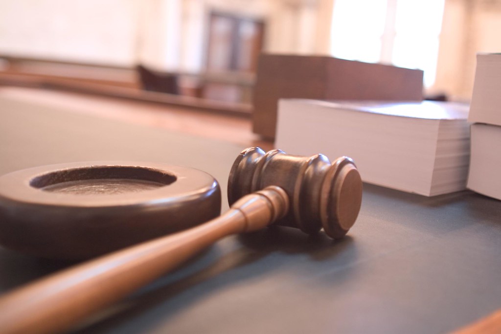 Wooden gavel resting on a courtroom bench
