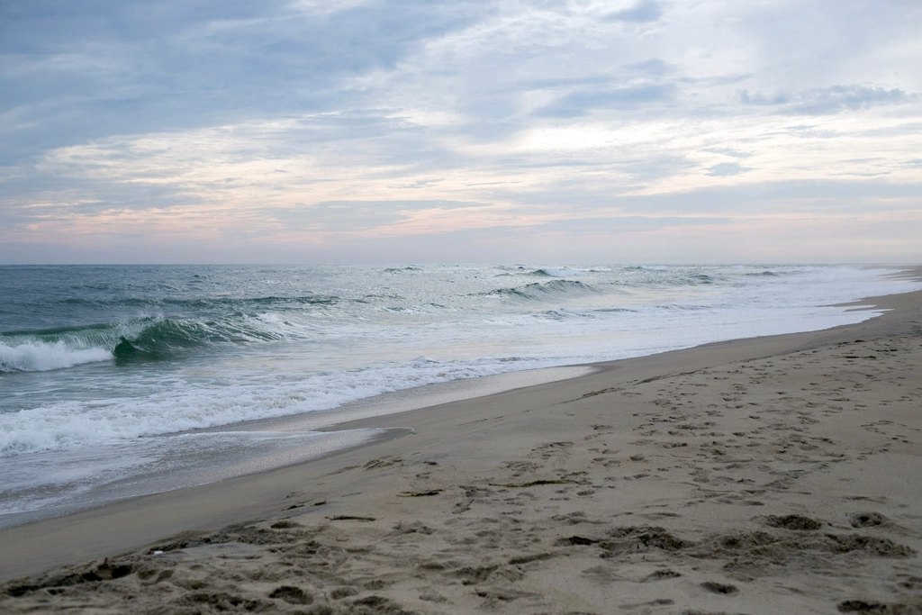 Waves rolling onto a flat sandy beach