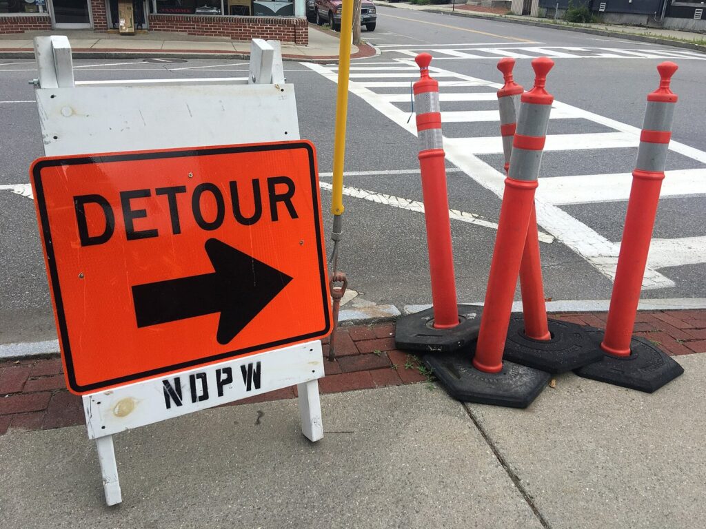 Orange detour sign and traffic posts at a closed city street